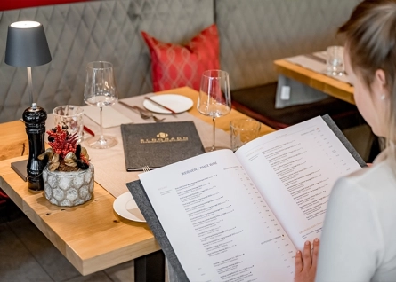 woman sitting at the table and reading the menu